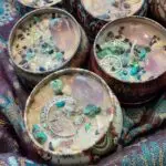 A group of candles with different colored rocks.