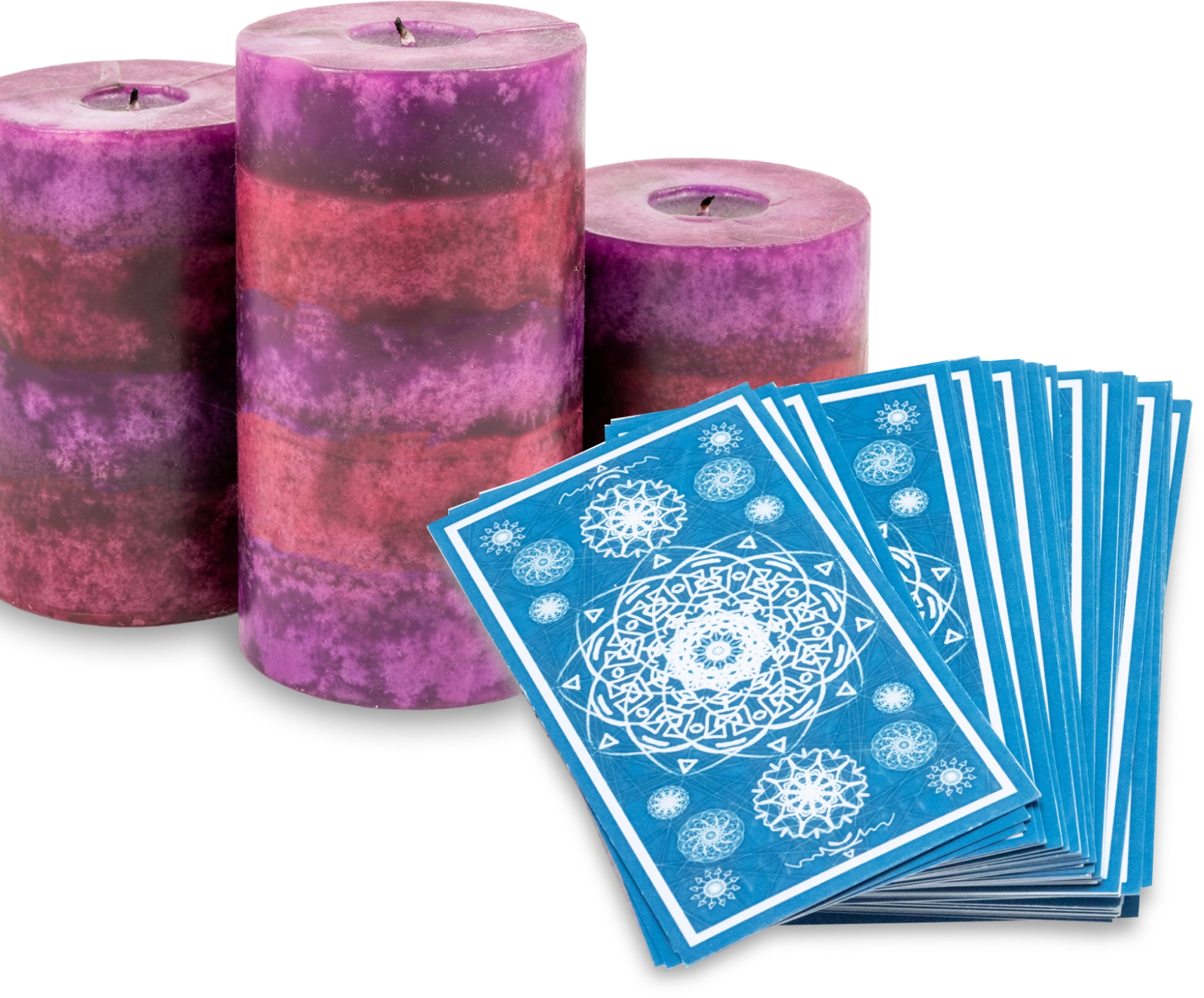 Three tall purple candles beside a stack of blue tarot cards with intricate white designs.